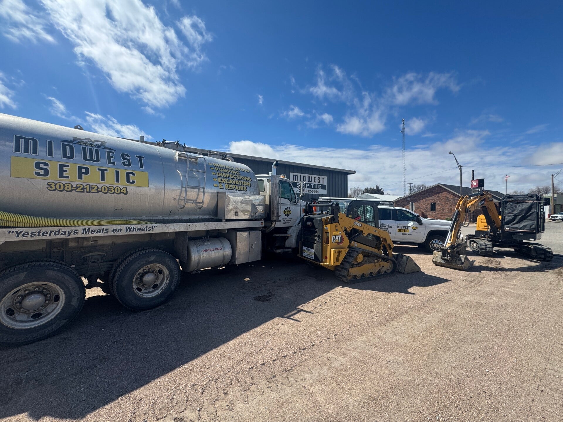 Midwest Septic pumping truck and excavation equipment outside their building